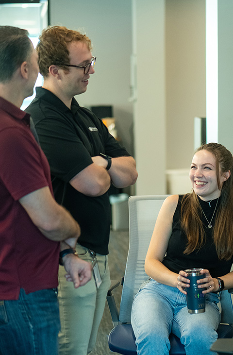 Three co-workers collabrating by a desk