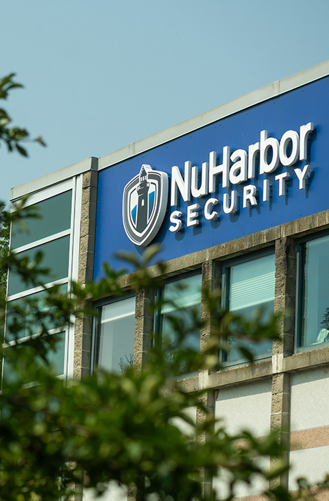Outside photo of a building with the NuHarbor Security logo at top of the building