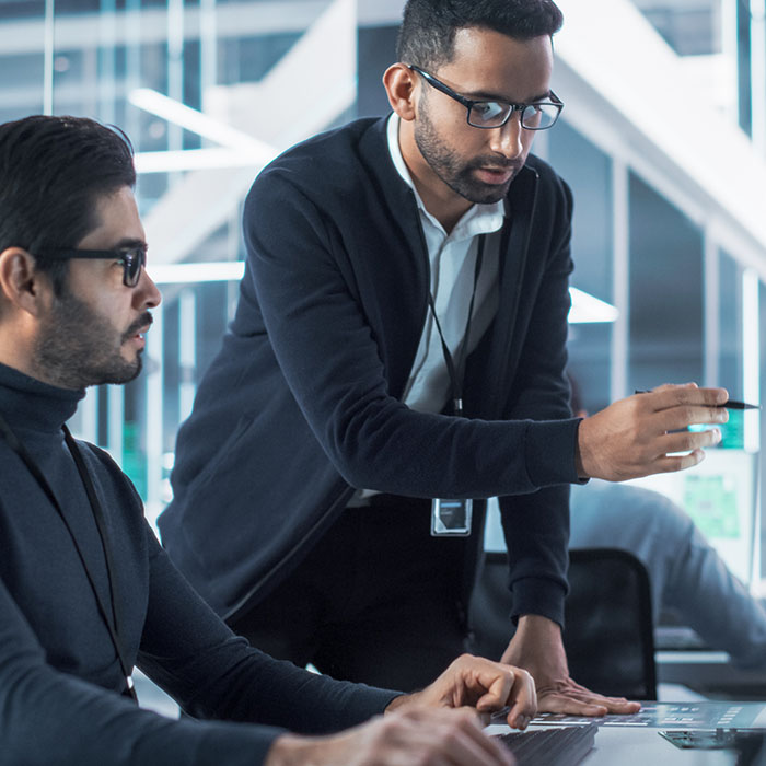 Man pointing at screen next to coworker