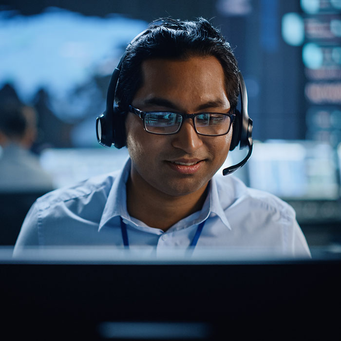 Man working at his desk on the phone with client