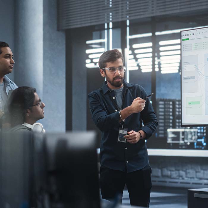 Team collaboration next to a screen.