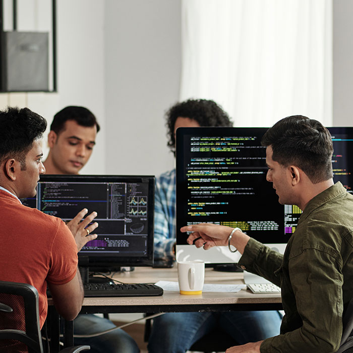 Team working at desk working on code.